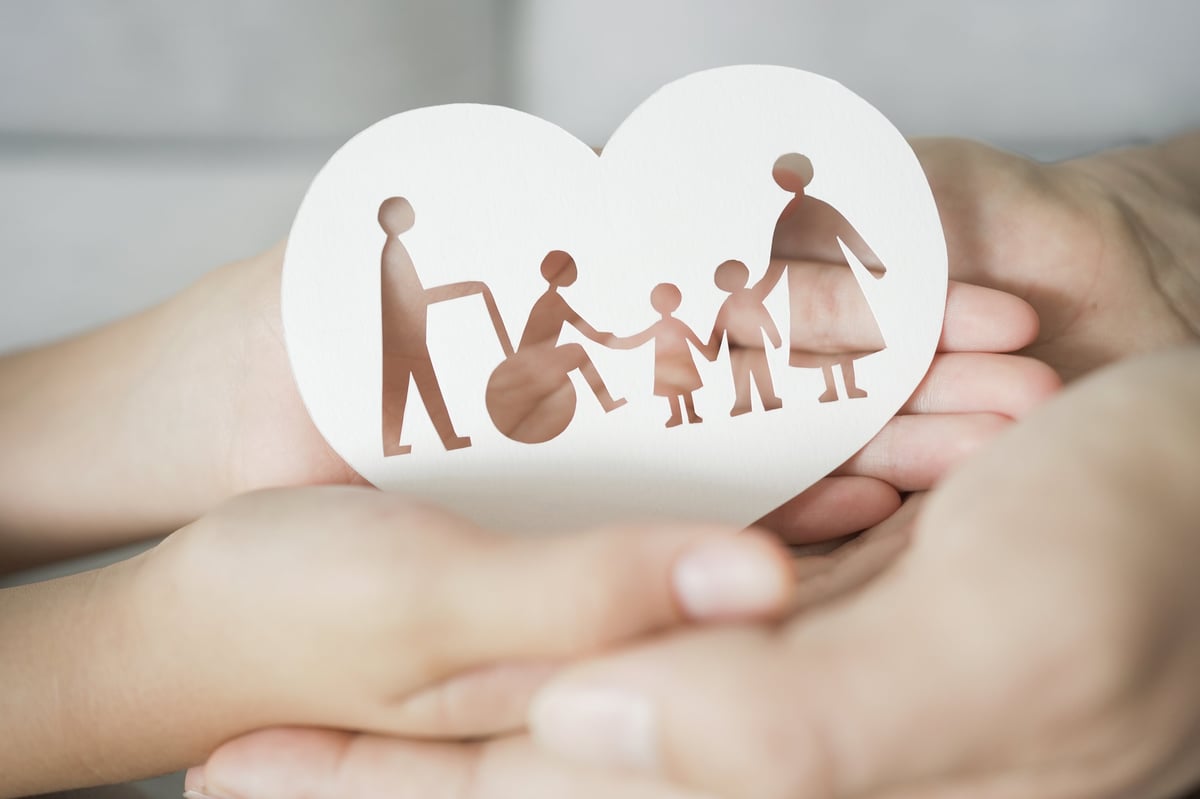 Happy caregiver and person with disability holding hands